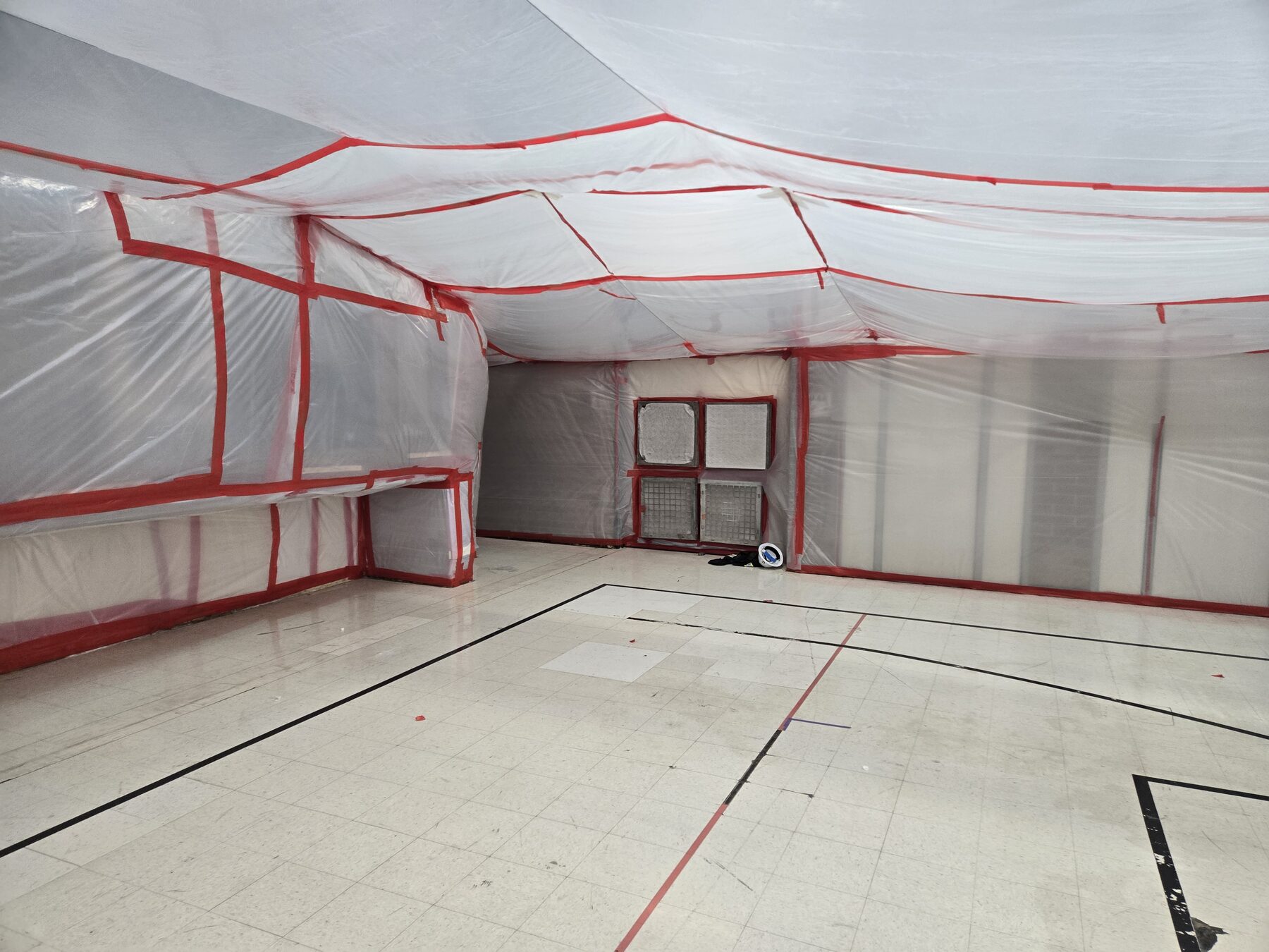 Poly-sheeted containment walls and decontamination chamber in a commercial space