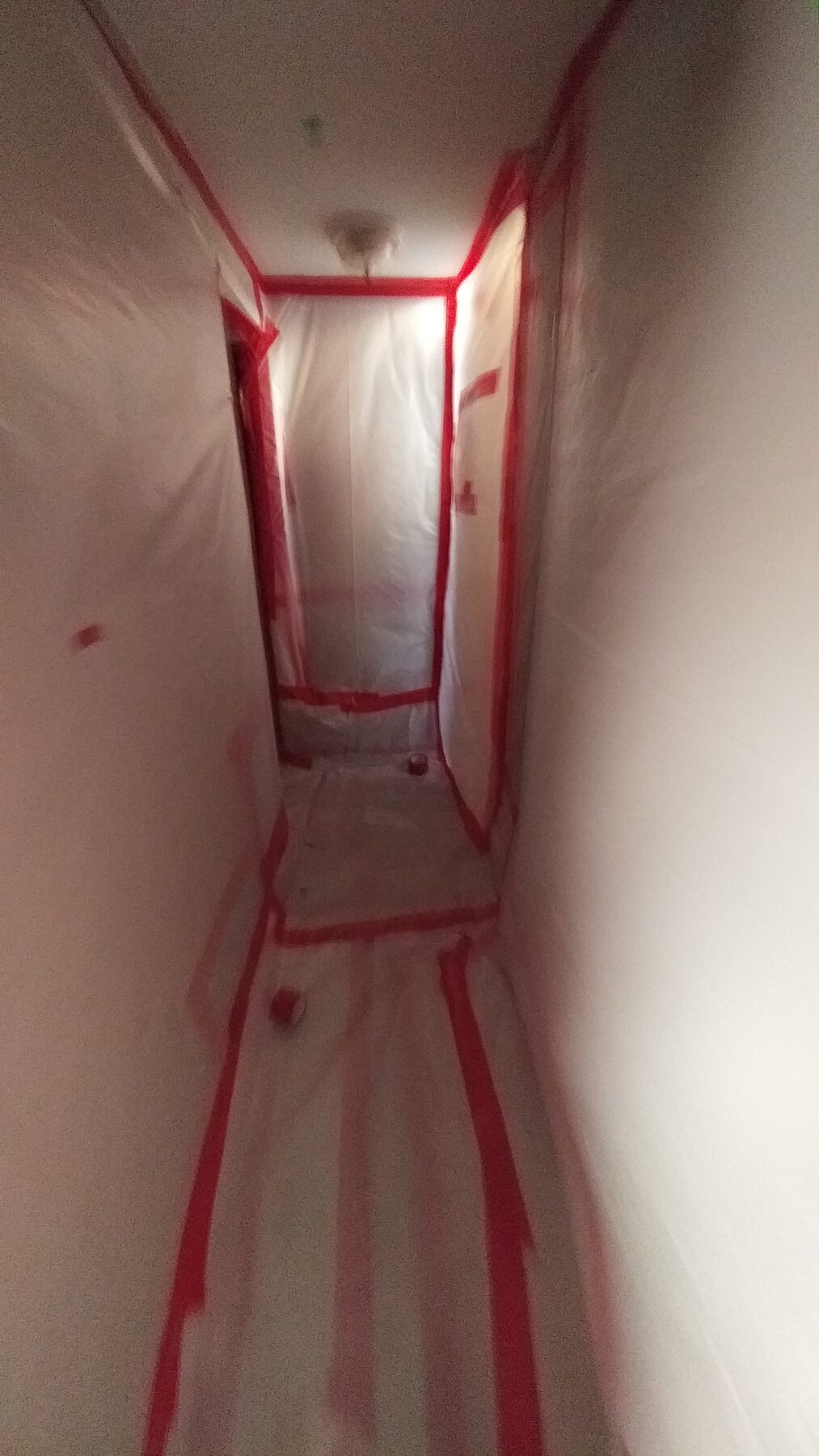 Residential hallway fully sheeted and taped for asbestos abatement